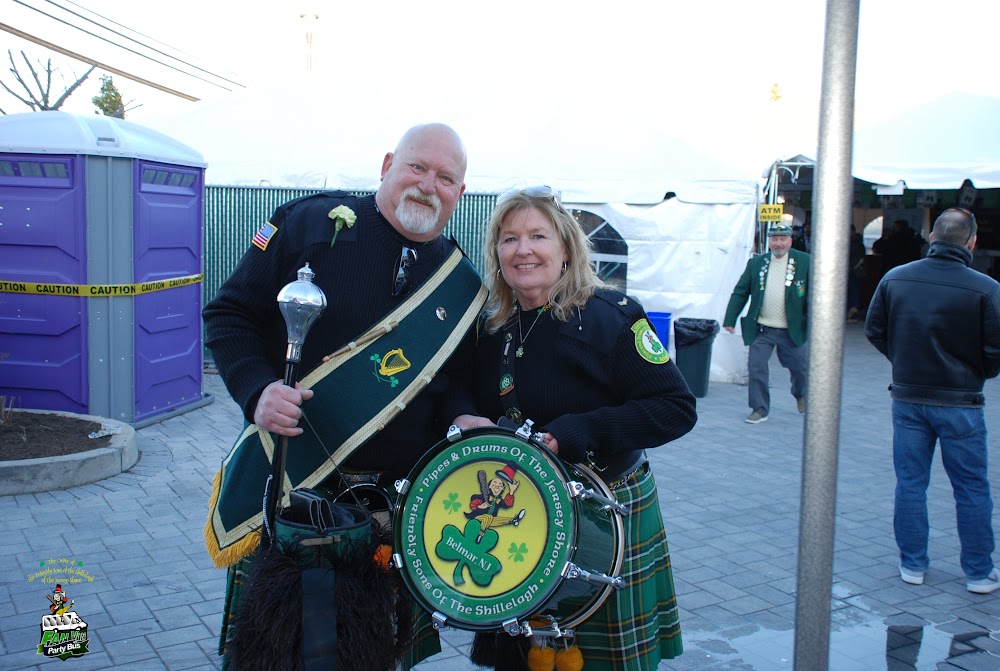 Two band members smiling together with a drum